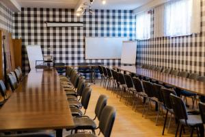 uma sala de conferências com mesas e cadeiras e um quadro branco em Hotel Kliper em Władysławowo