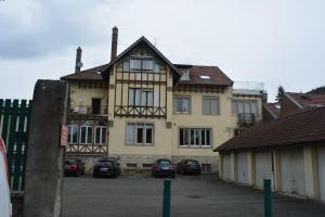 a large house with cars parked in front of it at Appartement-terrasse parking privé Meublé de Tourisme 4 étoiles in Belfort