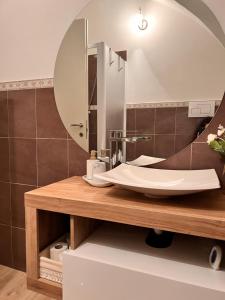 ein Bad mit einem Waschbecken und einem Spiegel in der Unterkunft L’Arco sul Lago • Gold Apartment in Castro