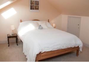 a bedroom with a white bed with a teddy bear on it at Owls Nest - Peace and Tranquility near Woodbridge & Framlingham in rural Suffolk in Woodbridge