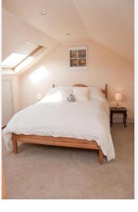 1 dormitorio con 1 cama grande con mantas y almohadas blancas en Owls Nest - Peace and Tranquility near Woodbridge & Framlingham in rural Suffolk en Woodbridge