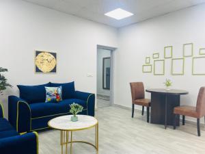 a waiting room with a blue couch and a table at OLIVE Service Apartments DLF Galleria Gurgaon in Gurgaon