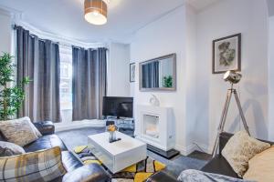 a living room with a couch and a fireplace at Pass the Keys Beautiful House in SouthChurch in Southend-on-Sea