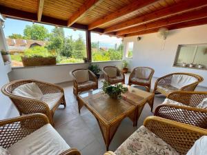 a patio with wicker chairs and a wooden table and a tableasteryasteryastery at Orhan Havaya in Sheʼar Yashuv