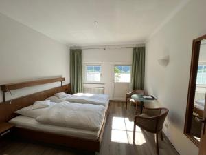 Hotel Schön في أسمانشاوسين: غرفة نوم بسرير ومكتب وكرسي