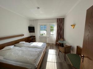 Hotel Schön في أسمانشاوسين: غرفة نوم بسرير وطاولة ونافذة