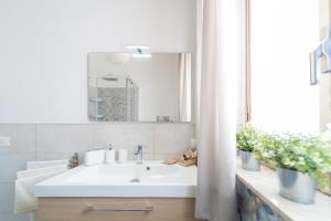 ein Badezimmer mit einem weißen Waschbecken und einem Spiegel in der Unterkunft Casa Lina con terrazza in Canicattini Bagni