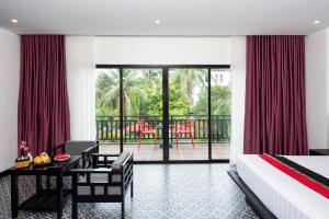 a bedroom with a bed and a desk and a balcony at Peak Elite Boutique in Siem Reap