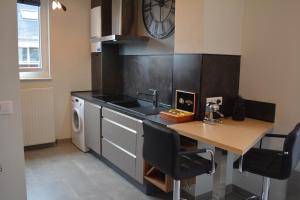 a kitchen with a table and a sink and a dishwasher at Appartement-terrasse parking privé Meublé de Tourisme 4 étoiles in Belfort