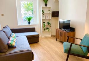 ein Wohnzimmer mit einem Sofa und einem Flachbild-TV in der Unterkunft Beautiful Two Bedroom Cottage in Morriston