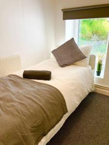 a bedroom with a large bed with a window at Beautiful Two Bedroom Cottage in Morriston