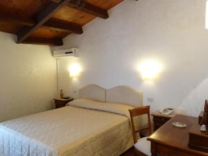 傑拉切的住宿－Hotel San Giuseppe，一间卧室配有一张床、一张桌子和一张书桌