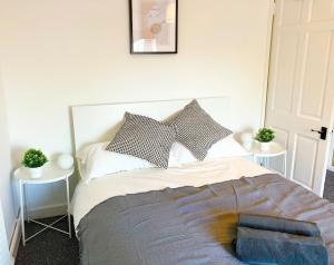 ein Schlafzimmer mit einem großen Bett mit zwei Tischen in der Unterkunft Beautiful Two Bedroom Cottage in Morriston