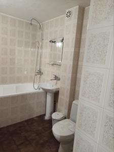 a bathroom with a toilet and a sink and a tub at Хотел ЗЛАТНА КОТВА in Kazanlŭk +40 photos