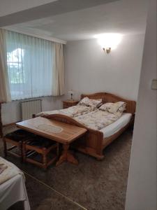 卡贊勒克的住宿－Хотел ЗЛАТНА КОТВА，一间卧室配有一张床和一张木桌