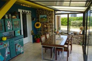 a kitchen with a table and chairs in a room at Villa Joret in Fermanville