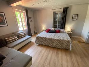 een slaapkamer met een bed en een bank bij Hôtel restaurant l'escale chez mimi in Bioule