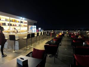 ein Restaurant mit einer Bar mit Tischen und Stühlen in der Nacht in der Unterkunft Lifestyle Luxury Hotel and Residence in Elwa