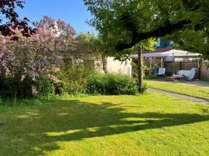 a yard with a tree and a house at Haus und Wohnung "Ohuus" für 6 Pers mit Garten in Büsum