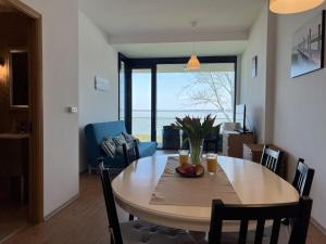 a dining room with a table with chairs and a view of the ocean at AMP Apartman - Siófok in Siófok