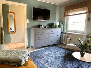 a living room with a dresser and a tv at Haus und Wohnung "Ohuus" für 6 Pers mit Garten in Büsum