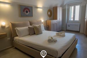 um quarto com uma cama grande e toalhas em Casa Filuga - City Centre em Alghero