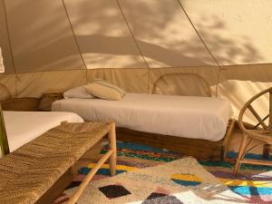 a room with two beds and a chair in a tent at Camping 3 Estrellas Costa Brava in Vall-Llobrega