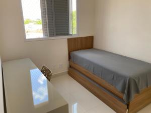 une chambre avec un lit et une table en verre dans l'établissement Apto novo, com ar, acesso rápido ao centro, à Uberlândia