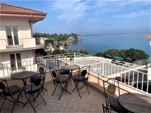 einen Balkon mit Tischen und Stühlen und Meerblick in der Unterkunft Bed and Breakfast Horizon in Tropea