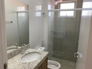 une salle de bain avec un lavabo, des toilettes et une douche dans l'établissement Apto novo, com ar, acesso rápido ao centro, à Uberlândia