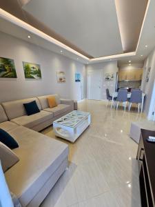 a living room with a couch and a table at Amazing Sea View Apartment in Sarandë