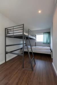 a bedroom with two bunk beds and a wooden floor at 54, Prachtige natuur voor fietsers! in Oisterwijk