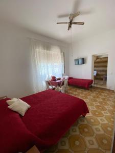 - une chambre avec un lit rouge et un salon dans l'établissement AFFITTACAMERE MINERVA, à Minervino di Lecce