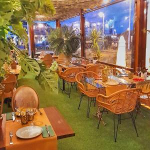 a restaurant with tables and chairs and a large window at Hotel Spa El Muelle de Suances in Suances