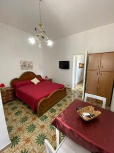 - une chambre avec un lit et une table avec un couvre-lit rouge dans l'établissement AFFITTACAMERE MINERVA, à Minervino di Lecce