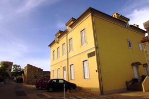 a yellow building with a car parked next to it at Apartment Tanja in Cres