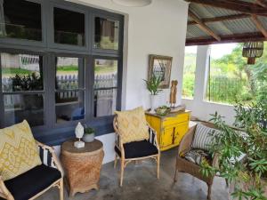 - une terrasse couverte avec 2 chaises, une table et des fenêtres dans l'établissement On 17th Voortrekker, à Paul Roux