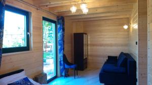 Habitación con sofá azul y ventana en Cztery Pory Roku pokoje z łazienkami do wynajęcia, en Osiek