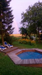 una piscina con 2 sillas y un arco iris en el fondo en Cztery Pory Roku pokoje z łazienkami do wynajęcia, en Osiek