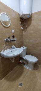 uma casa de banho com um WC, um lavatório e um espelho. em East Gate Guest Rooms em Plovdiv