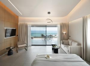 a hotel room with a bed and a view of the ocean at Anasa Luxury Resort in Elaiokhórion