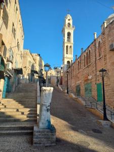 an empty street with a clock tower in the background at Dar al Majus in Bethlehem
