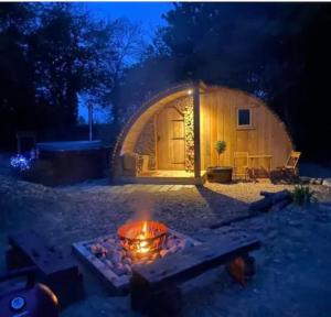 a fire pit in front of a dome house at night at Fox Lodge at Heygates Lodging - with hot tub in Yelvertoft