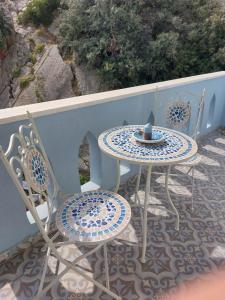 a table and chairs sitting on a balcony with a view at Colorful House Tsoutsouras in Tsoútsouros