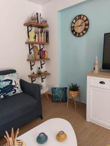 a living room with a couch and a clock on the wall at Colorful House Tsoutsouras in Tsoutsouros