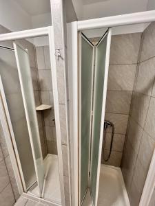 a shower with a glass door in a bathroom at Split It Hostel in Split