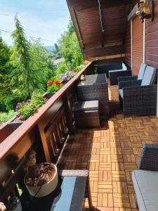 patio z kanapami, krzesłami i kwiatami w obiekcie Haus Flora - Ferienwohnung Bodensdorf w mieście Bodensdorf
