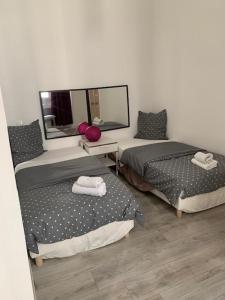 カンヌにあるCANNES CROISETTE bのベッド2台と鏡が備わる客室です。