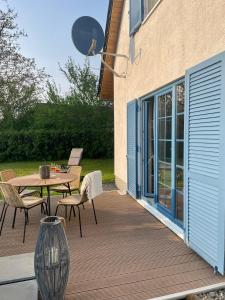 eine Holzterrasse mit einem Tisch und Stühlen darauf in der Unterkunft Ferienhaus Biedermann in Wiek auf Rügen 