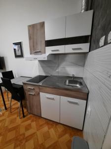 cocina con fregadero y mesa con silla en Apartman STEVAN Vrnjačka Banja, en Vrnjačka Banja
